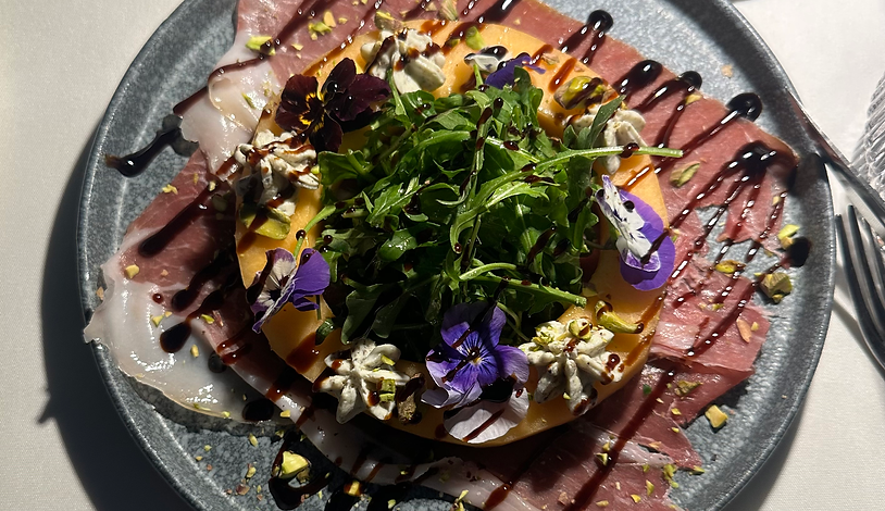 Melon Salad with arugula, prosciutto and edible flowers