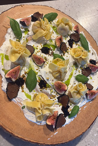Tortellini with fresh figs and black truffle on whipped ricotta